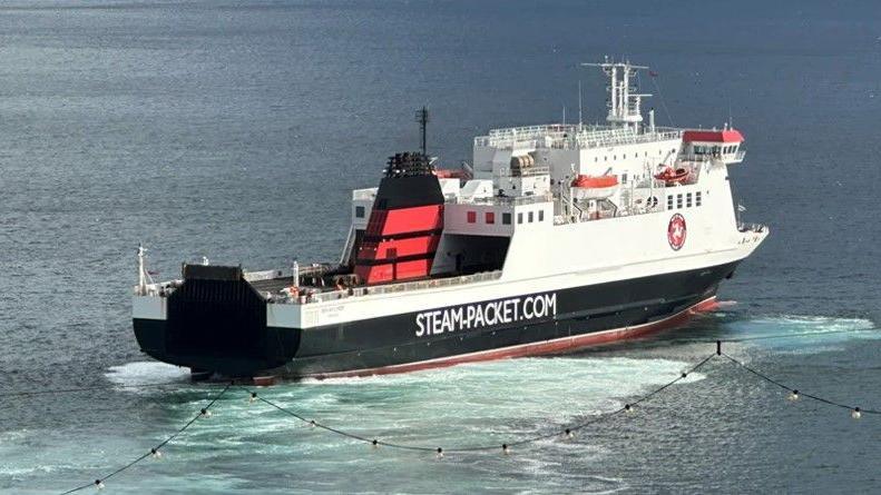 The Ben-My-Chree in Douglas Bay. It is a large white, black and red vessel with STEAM-PACKET.COM written on the side.