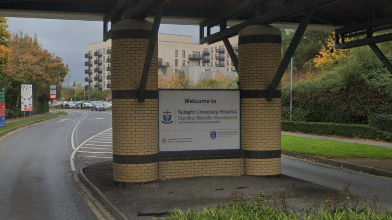 The entrance to Tallaght hospital. It has yellow bricks and a white sign that says welcome to Tallaght hospital. 