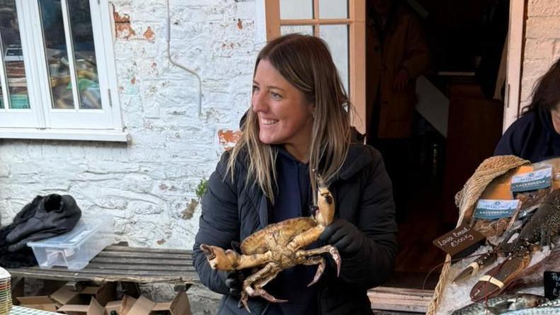 Emma yn gafael mewn cranc