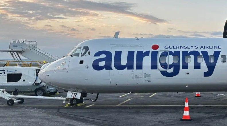 Aurigny plane - blue text and white plane. Orange and white cone on a runway with the plane