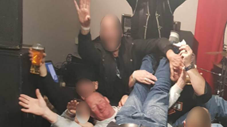 Robert, bottom left, posing in front of a Nazi flag