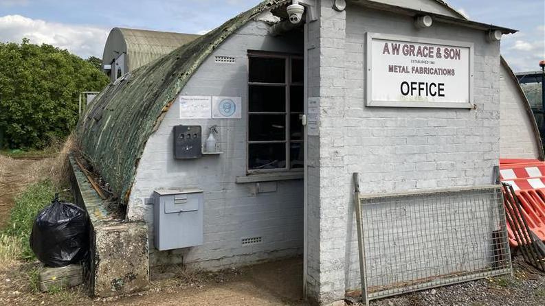 Nissen hut premises with AW Grace sign