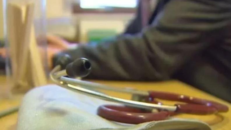 Doctor at a desk behind a stethoscope