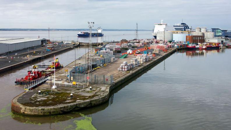 A working dock with a ferry leaving in the background