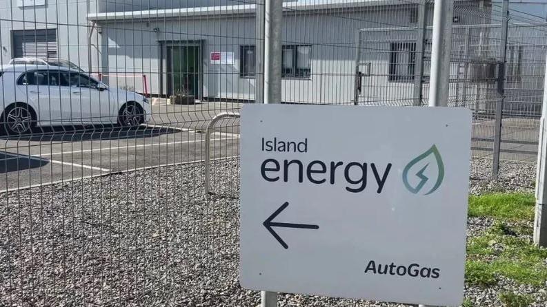 A white sign with Island Energy written on it with an arrow below and the company logo to the right. At the bottom right it says Autogas