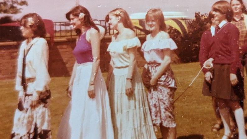 The Nolans in late 70s floral skirt pose by a skipping rope in a photocall at their old school