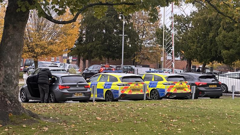 Two police cars parked in a car park at Reading College.