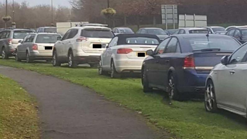 Cars parked on a grass verge