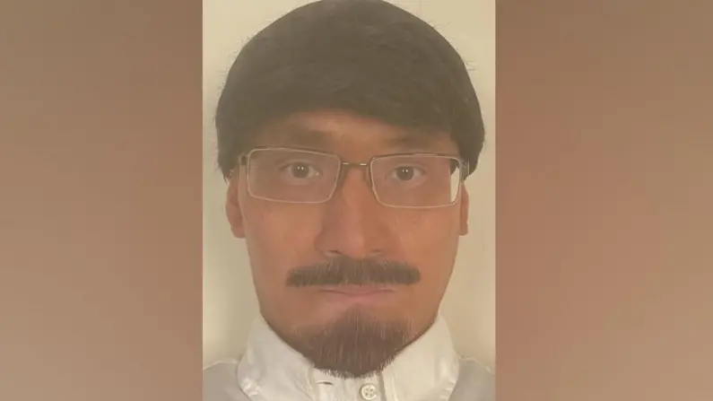 An ID image Kwan took of himself showing him with tanned skin and wearing a fake beard, moustache and wig.