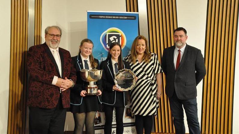 Sgioba Sgoil Sir E Scott còmhla ris na britheamhan às dèidh dhaibh Deasbad Nàiseanta nan Àrd-sgoiltean a bhuannachadh ann an 2025