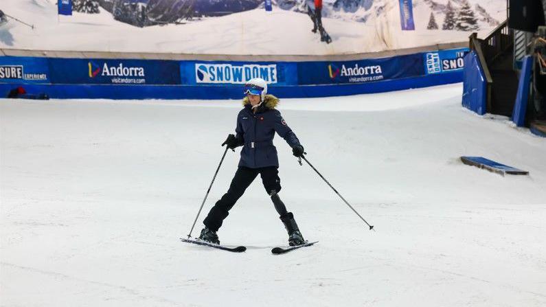 A girl with a prosthetic leg skiing down a slope