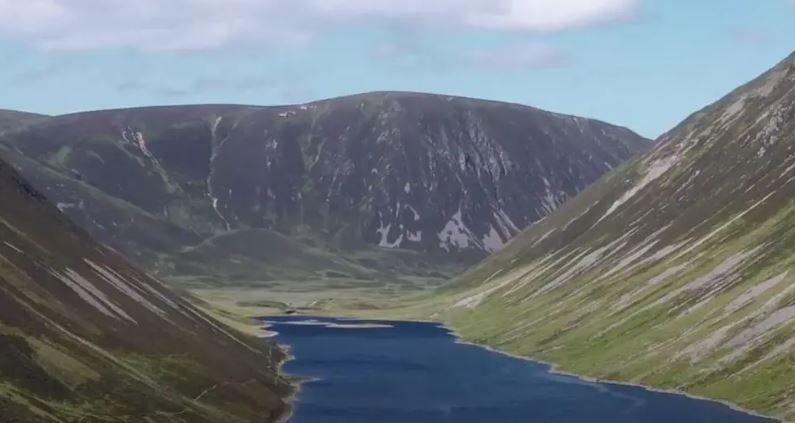 Dalnacardoch Estate pictured showing a large lake with large mountains either side and in front of the lake.