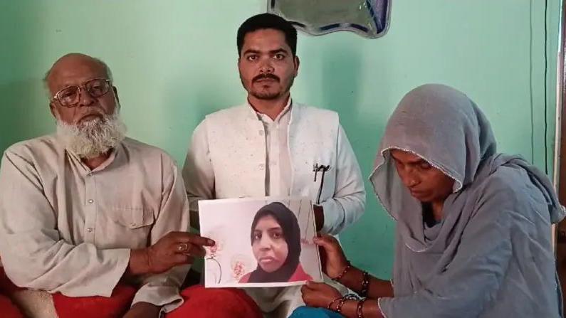 An Abu Dhabi court executed an Indian domestic worker for killing an infant. Her family members, who maintain she was innocent, hold her portrait in which she can be seen wearing a black scarf.