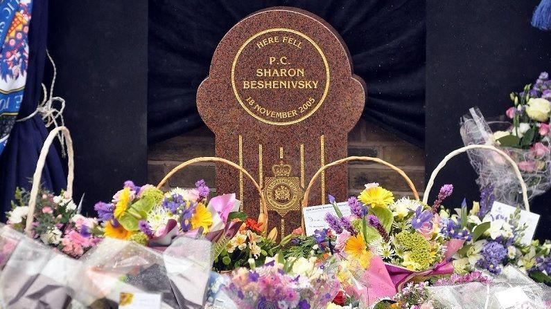 Flowers and tributes lay in front of a memorial stone, which reads: "Here fell PC Sharon Beshenivsky".