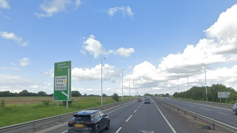 Google Maps image of the A12 near Kelvedon showing a large green sign to highlight the Kelvedon exit. The roads in this image are relatively clear and the sky is blue with some clouds.