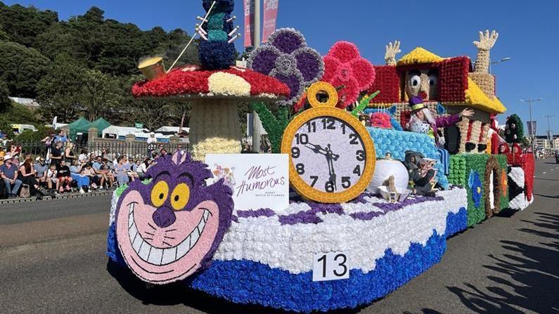 An Alice in Wonderland themed float featuring a clock a mushroom and a cheshire cat