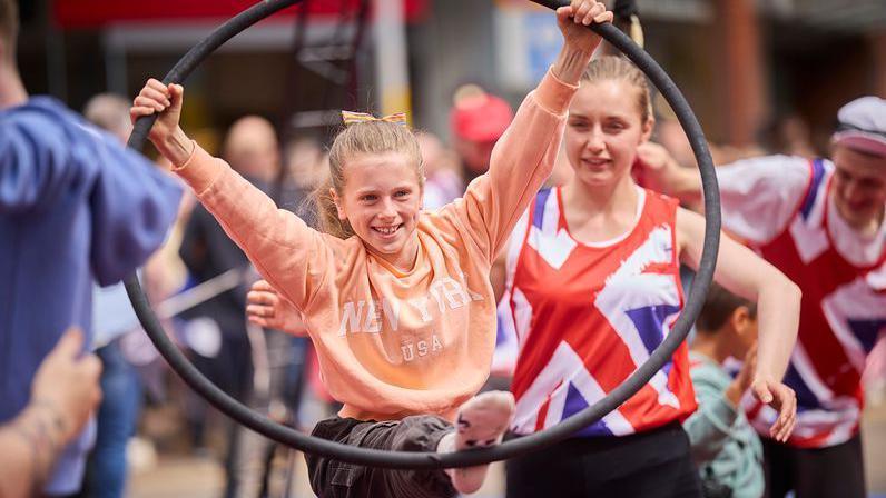 A girl shows off her gymnastic skills with a hoop