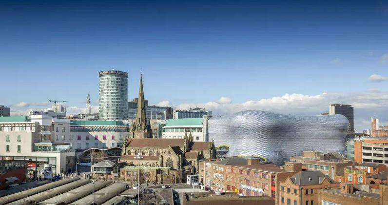 Birmingham city centre skyline bathed in sunshine and showing the rotunda, Selfridges and St Martin in the Bull Ring church