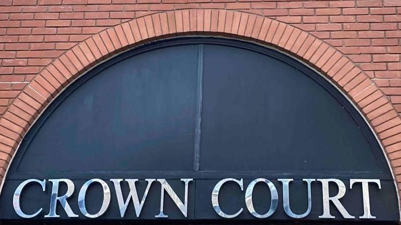 St Albans Crown Court: The words "CROWN COURT" written in silver on a blue semi-circular background.