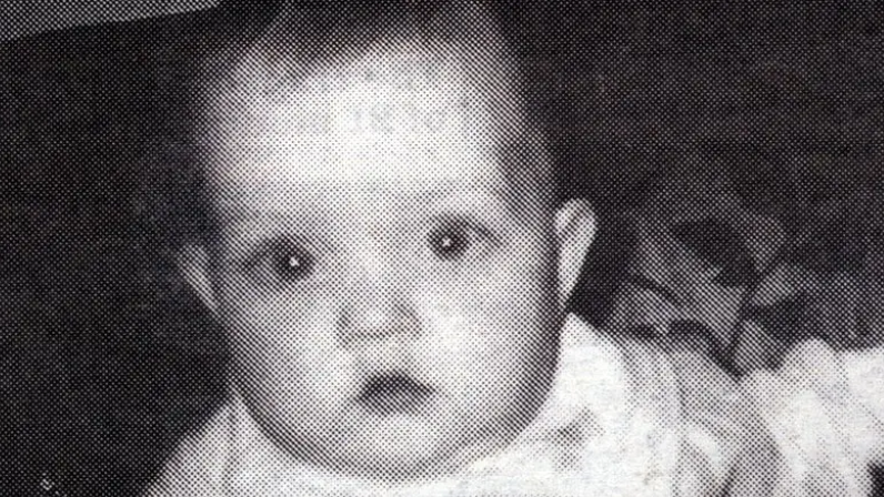 Black and white photo of a baby looking at the camera