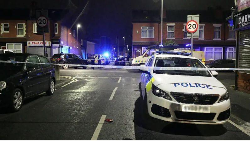 A police cordon is in place blocking off the street with a number of police vehicles present.