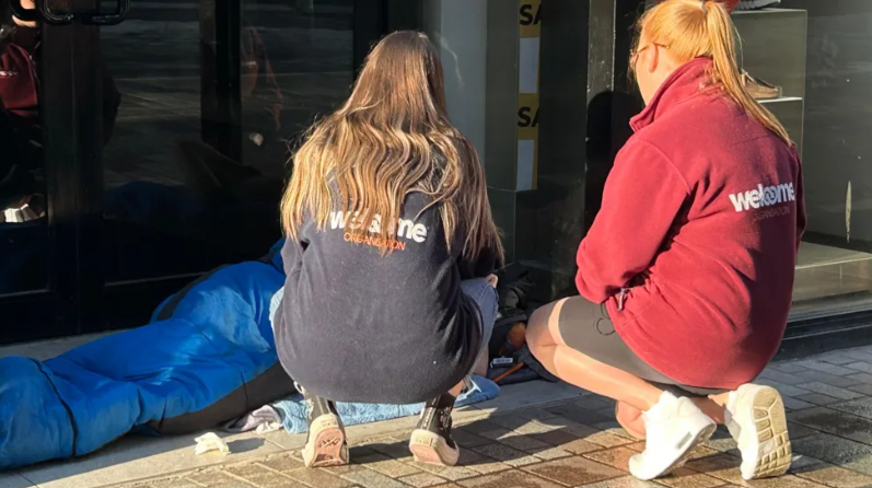 Female Welcome volunteers with homeless person on Belfast street