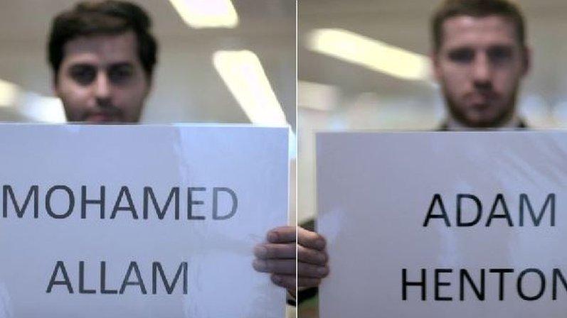 Applicants hold signs with names Mohamed and Adam