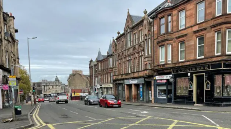 A view of flats and business premises on Quarry Street in Hamilton with cars on the road