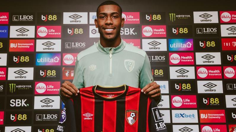 Rayan holding a Bournemouth shirt