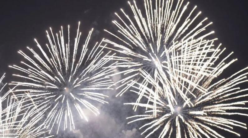 Four big white exploding fireworks making lines against a black sky.