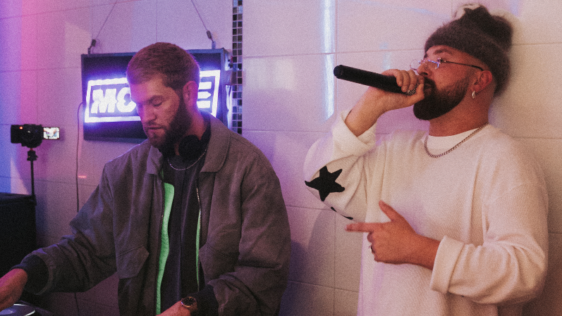 MC Window Kid and DJ and producer Nathan Dawe behind the counter of a chip shop