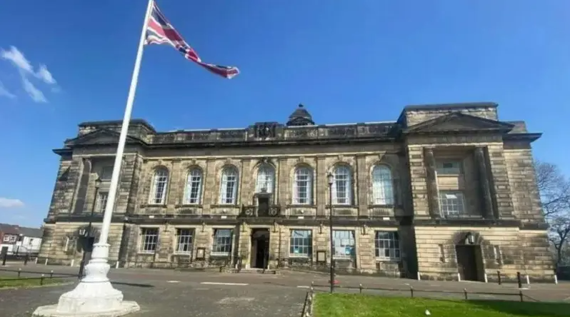 The outside of the Wirral Council building, and a Union Flag at full mast.