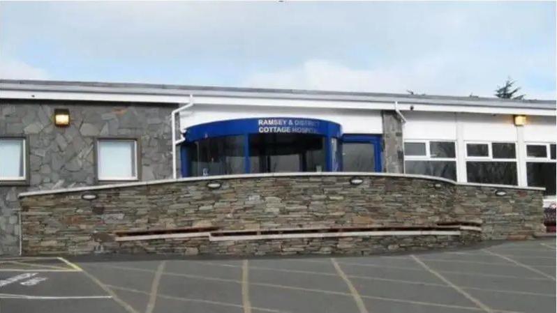 The exterior Ramsey District Cottage Hospital, the entrance is blue, and there is a stone ramp to the entrance.