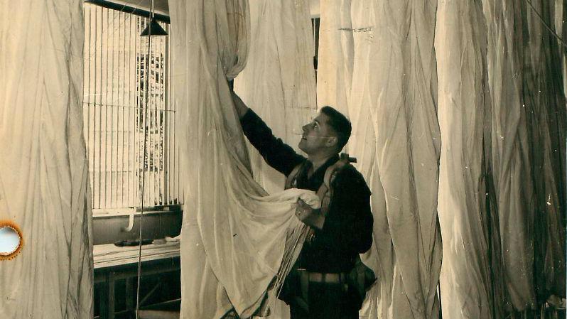 A paratrooper hangs up parachute silk to dry at Tatton Park