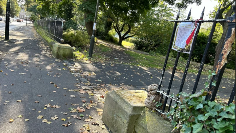 One of the entrances to Leazes Park with railings on either side. Two concrete bases are on either side of the entrance but are missing the pillars.