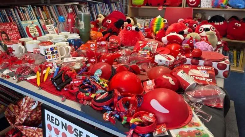 a table full of red nose day merchandise