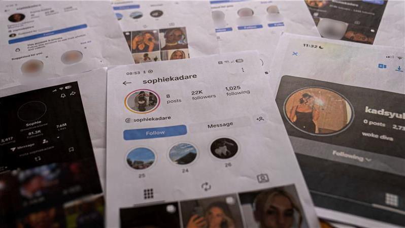 Saith print A4 o sgrinluniau o gyfrifon ffug Sophie Kadare wedi'u gosod ar fwrdd.