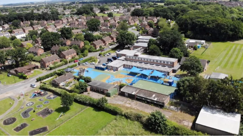 Aerial image of Howard Junior School surrounded by green playing fields and residential housing