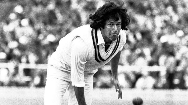 Imran Khan bowling. He is in cricket whites and has long black hair.