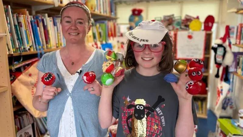 Ziggy and his mum holding up lots of comic relief red noses