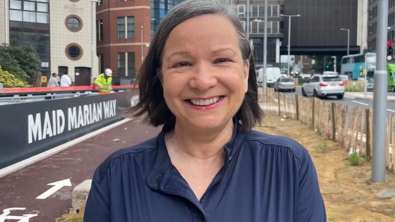 Councillor Linda Woodings stood near the new T-junction at Maid Marian Way, with work to install green areas ongoing behind her.