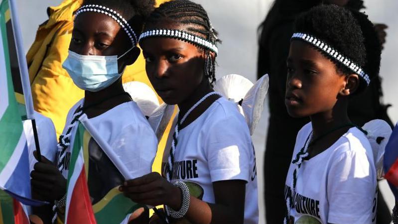 Children dressed in Minwenda traditional attire from Venda wave South African flags before the start of Cyril Ramaphosa's inauguration ceremony as South African president at the Union Buildings in Pretoria, South Africa, 19 June 2024