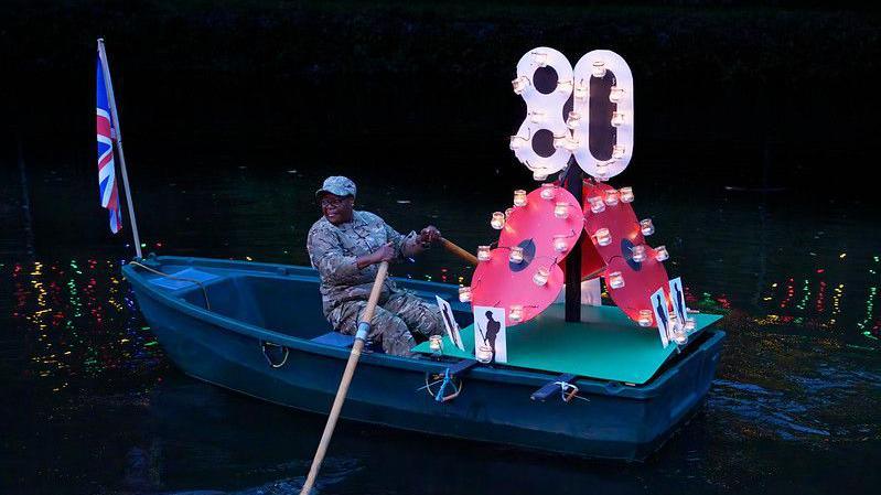 A Remembrance candle boat being rowed