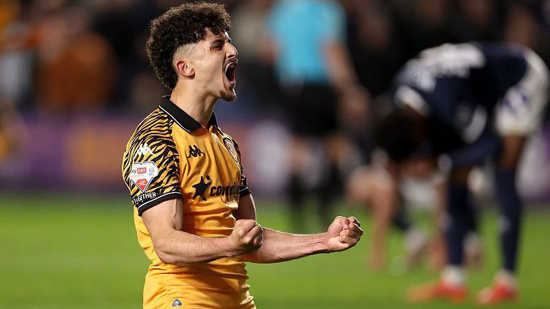 Mo Belloumi kneels down and celebrates with his fists clenched after scoring for Hull City