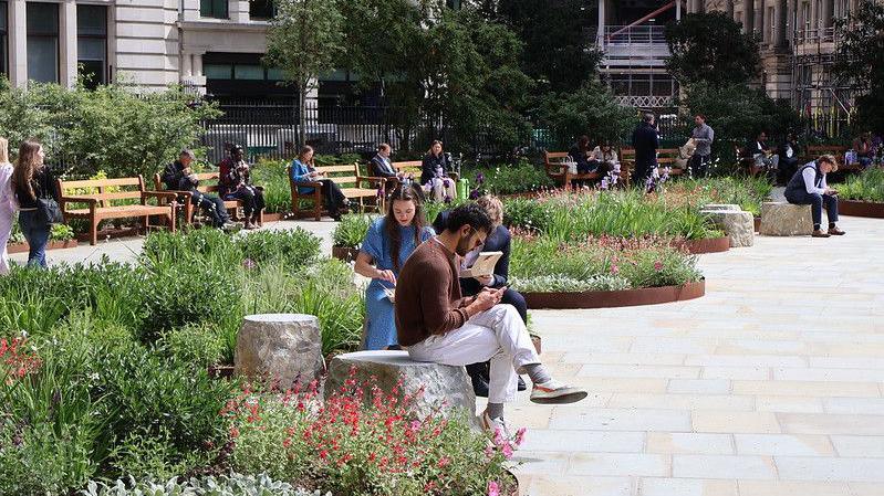 People sit on seating in the newly opened Finsbury Circus Gardens