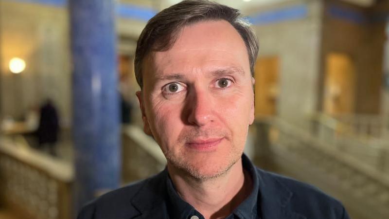 Andrew Pakes MP, looking straight ahead. He is wearing a dark blue shirt.
