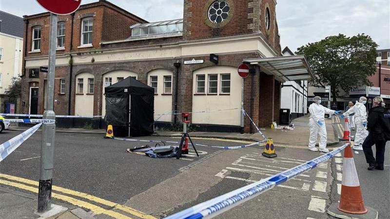 An area of a town centre is cordoned off with police tape.