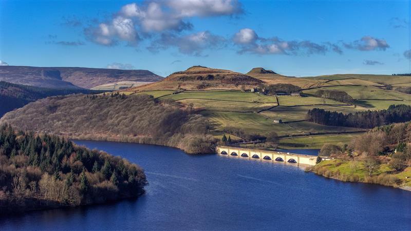 Vast hillside landscape in front of large blue lake