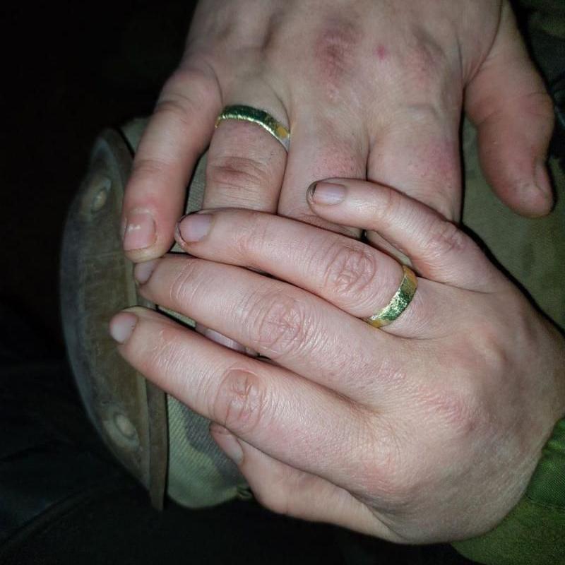 Close of Andriy and Valeria's hands with tin-foil rings