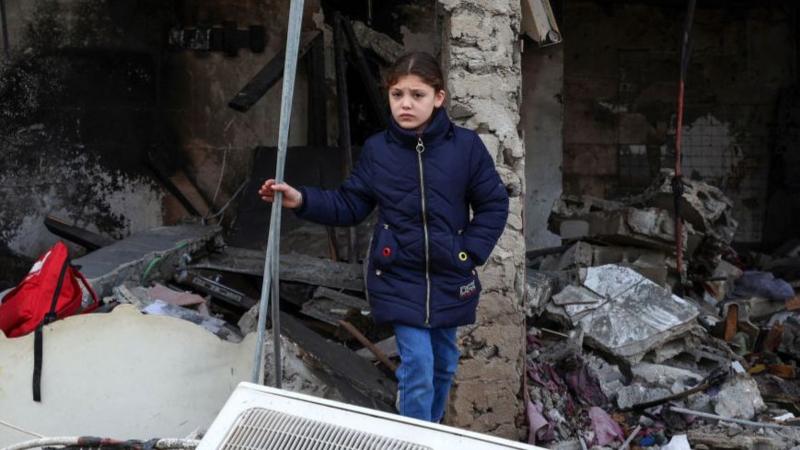 Girl stands after air strike in Gaza